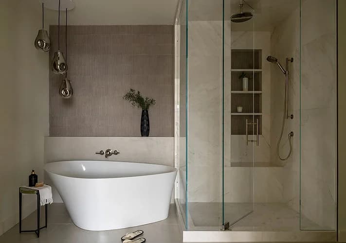 A bathroom with a freestanding tub beside a glass-enclosed shower.