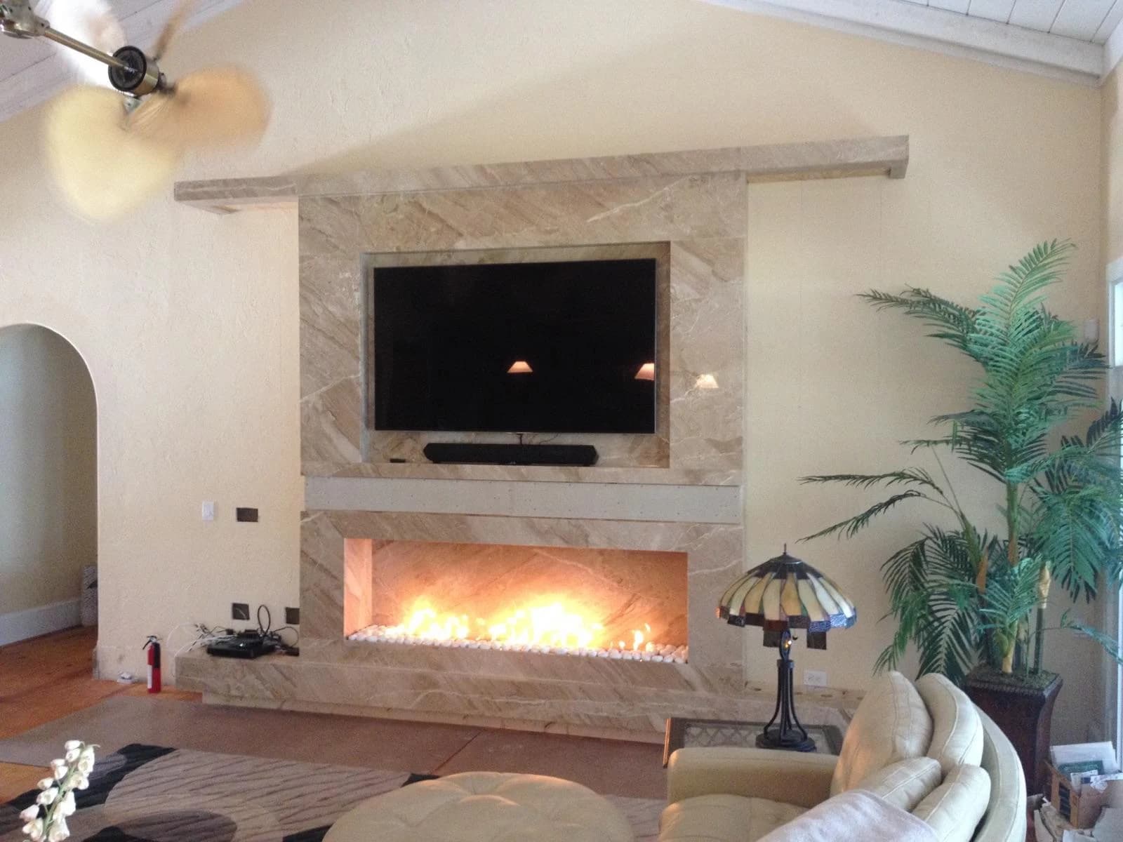 A stone fireplace and media wall in a completed living room.